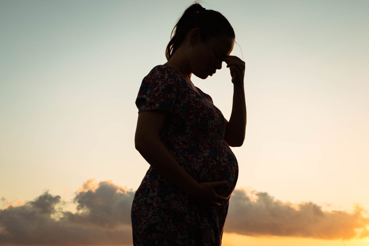silhouetted, upset pregnant woman