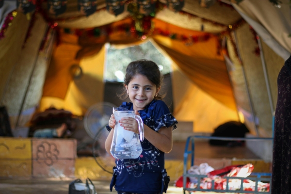 smiling girl holds water jug