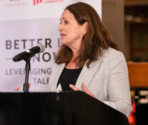 Sarah Costa speaking at podium